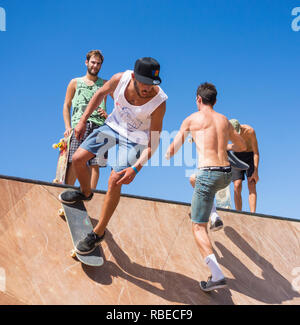 Guidatore di skateboard sulla rampa di skateboard in skatepark. Foto Stock