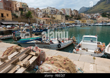 Piccole barche da pesca e reti da pesca nel porto nel centro della cittadina di Castellammare del Golfo vicino a Scopello sull isola di Sicilia, Italia. Foto Stock