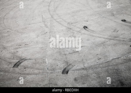 Trasporto astratto foto di sfondo con tracce di pneumatici su grigio strada concreta Foto Stock