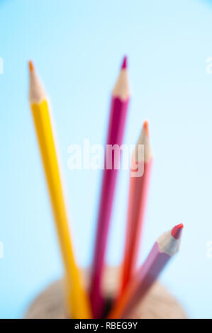 Matite di colore e la stringa cesto su sfondo blu Foto Stock