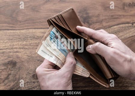 Tenendo le mani pila di denaro contante al di fuori del portafoglio Foto Stock