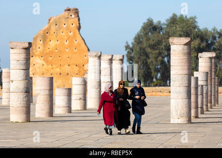 Rabat, Marocco - 29 Novembre 2018: le donne a piedi vicino alla Torre Hassan o Tour Hassan che è il minareto di una moschea incompleto a Rabat, Marocco. Residuo Foto Stock