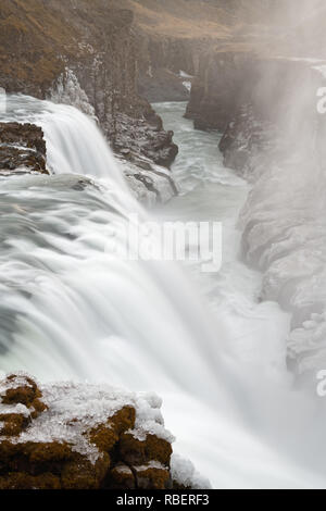Vista in dettaglio di una grande cascata, movimento di acqua in una lunga esposizione, la formazione di ghiaccio sulla riva del mare, la vista è portato a sfondo - Location: Islanda, Foto Stock
