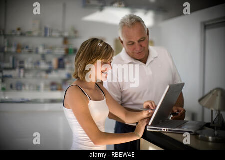 Una giovane donna con un senior l'uomo lavora sul computer portatile. Foto Stock