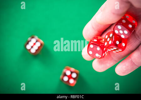 Gettando rosso dadi poker casinò sul tavolo verde. Foto Stock