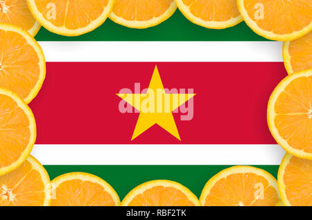 Suriname bandiera in frame di orange agrumi fette. Concetto di crescita nonché di importazione ed esportazione di agrumi Foto Stock