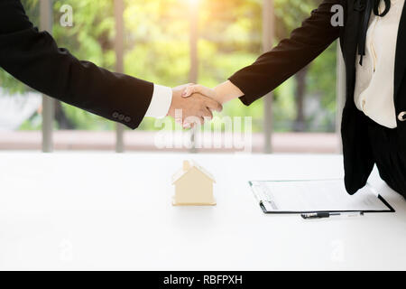 Agente immobiliare e il cliente si stringono la mano dopo la firma di un contratto: immobiliare, casa prestito e concetto di assicurazione Foto Stock