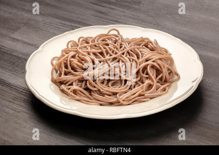 Una foto di un piatto di soba, Tagliatelle di grano saraceno, su sfondo nero Foto Stock