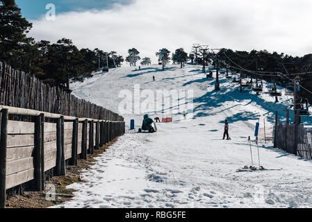 Navacerrada, Spagna - 7 Dicembre 2017: sciatori sci in discesa nella stazione sciistica di Guadarrama mountain range in inverno una giornata soleggiata con cielo blu Foto Stock