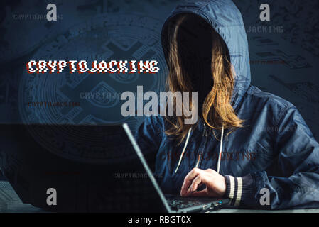 Una ragazza hacker senza volto sta cercando di rubare cryptocurrency utilizzando un computer. Frode e truffa a Cryptojacking Foto Stock