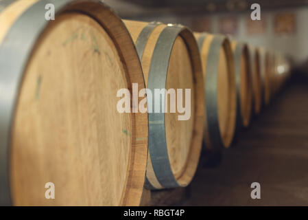 Il vino in botti di rovere in cui il vino rosso è affinato in cantina dell'azienda vinicola. Il concetto di produzione di vino Foto Stock