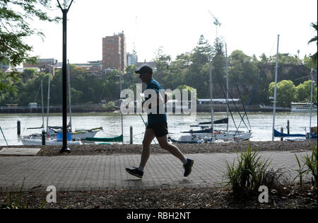 Un uomo che corre in città Giardini Botanici di Brisbane, Queensland, Australia Foto Stock