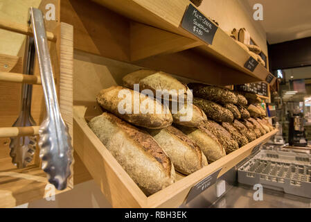 Pasta acida fresca Pane impilati pronti per la vendita in un Sydney, Australia panificio Foto Stock