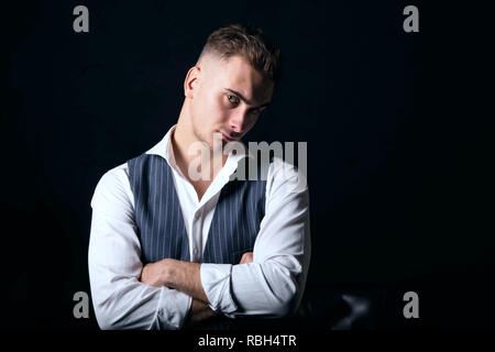 Ritratto di giovane uomo bello indossare una camicia bianca in piedi su sfondo nero Foto Stock