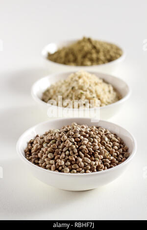 Organico tutta canapa semi, semi mondati e proteine in polvere in ciotole su uno sfondo bianco, verticale Foto Stock