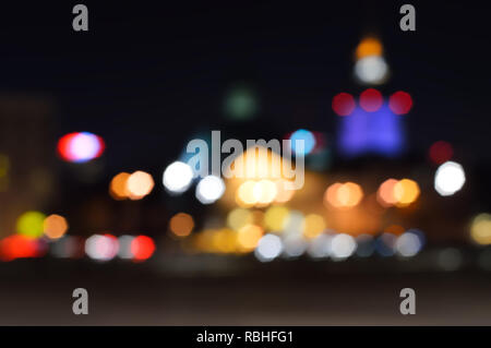 Luci di sfocatura cityscape nella notte per un background. Bokeh sfocato di notte le luci in una città di Varsavia. Foto Stock