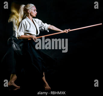 Uno caucasico combattenti bodoka donna pratica Bo-Jutsu studio shot isolato su sfondo nero Foto Stock