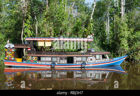 Un dipinto fancifully klotok o houseboat, del Borneo's Sungai Sekonyer river è il trasporto per i turisti desiderosi di vedere orangutan Foto Stock