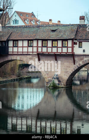 Close-up di un ponte medievale riflesso nel fiume nella pittoresca città vecchia di Norimberga / Norimberga durante il periodo invernale (Norimberga, Germania, Europa) Foto Stock