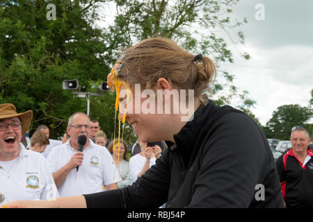 Partecipante a giocare alla roulette russa con le uova al mondo uovo gettando campionati, Swaton Village Fair, Lincolnshire, Regno Unito Foto Stock