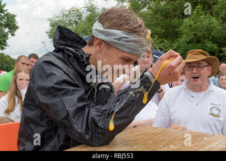 Partecipante a giocare alla roulette russa con le uova al mondo uovo gettando campionati, Swaton Village Fair, Lincolnshire, Regno Unito Foto Stock