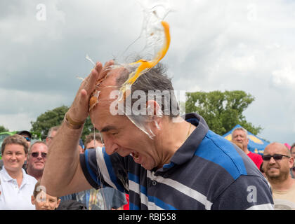 Partecipante a giocare alla roulette russa con le uova al mondo uovo gettando campionati, Swaton Village Fair, Lincolnshire, Regno Unito Foto Stock