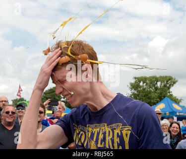 Partecipante a giocare alla roulette russa con le uova al mondo uovo gettando campionati, Swaton Village Fair, Lincolnshire, Regno Unito Foto Stock