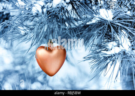 Giocattolo a forma di cuore appeso a un Nuovo Anno Albero. Tonificanti Foto Stock