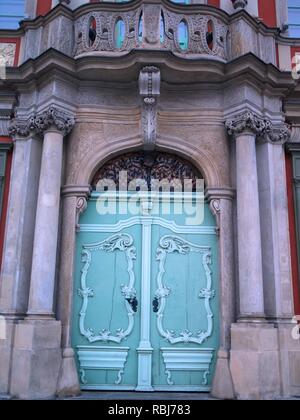 Luce verde ornati in legno vintage doppia porta di entrata con intaglio decorativo e colonne di pietra Foto Stock