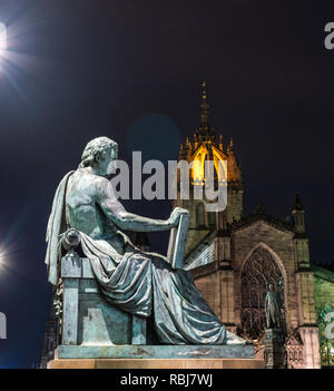 David Hume statua da Alexander Stoddart illuminata di notte con la Cattedrale di St Giles, Royal Mile di Edimburgo, Scozia, Regno Unito Foto Stock