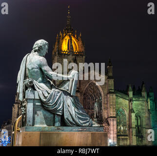 David Hume statua da Alexander Stoddart illuminata di notte con la Cattedrale di St Giles, Royal Mile di Edimburgo, Scozia, Regno Unito Foto Stock
