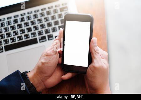 Mockup immagine di una mano di un uomo bianco di contenimento mobile phone con nera vuota nella schermata del desktop sulla coscia in cafe Foto Stock