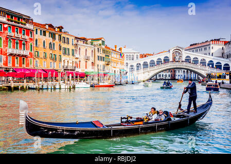 Venezia, Italia - Febbraio 2018: Gondola sul Canal Grande, il Ponte Rialto Waterfront, punto di riferimento di Venezia. Foto Stock