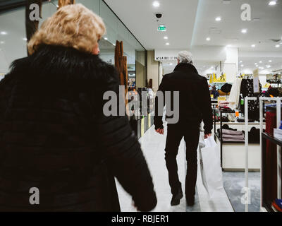 Strasburgo, Francia - 11 GEN 2018: vista posteriore del senior alla moda giovane a piedi nella Printemps Luxury department store durante la stagione delle vendite ammirando la femmina borse in pelle Foto Stock