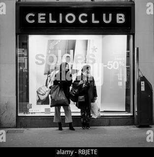 Strasburgo, Francia - 11 GEN 2018: due donne, madre e figlia in attesa nella parte anteriore della moda store window Celio durante la vendita Soldes stagione - immagine in bianco e nero Foto Stock