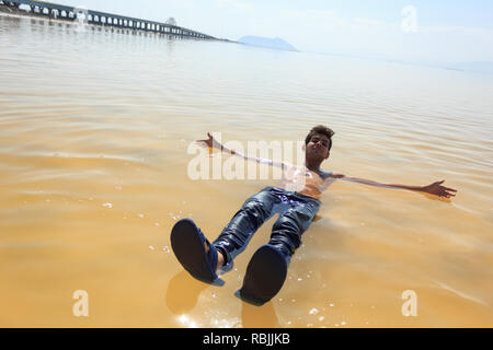 Il giovane uomo è nuotare nel sale Urmia Lake, West Azerbaijan provincia, Iran Foto Stock