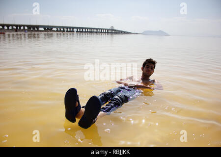 Il giovane uomo è nuotare nel sale Urmia Lake, West Azerbaijan provincia, Iran Foto Stock