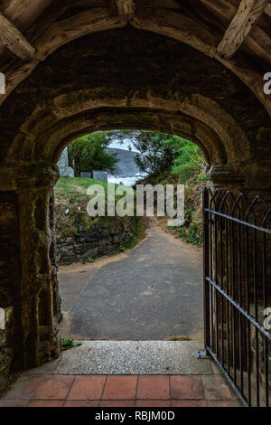 Gunwalloe Cove Chiesa attraverso l'ingresso verso la spiaggia Foto Stock