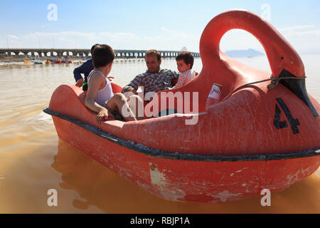 Un uomo è in sella a una barca a pedali con i suoi figli sul lago di Urmia, West Azerbaijan provincia, Iran Foto Stock