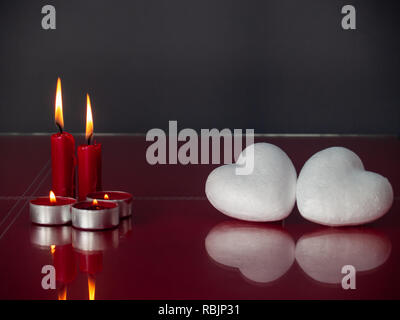 Concetto di amore poliespan due cuori uniti con un filo rosso che  simboleggia la leggenda del filo rosso e rosso due candele accese Foto stock  - Alamy