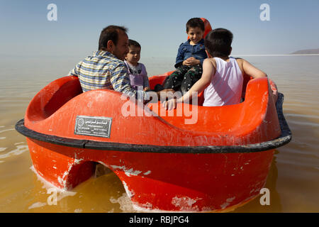 Un uomo è in sella a una barca a pedali con i suoi figli sul lago di Urmia, West Azerbaijan provincia, Iran Foto Stock