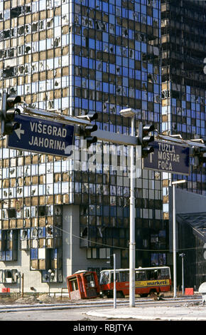 Il 15 marzo 1993 durante l'assedio di Sarajevo: un bus abbandonati alla base del Unis torri su Sniper Alley. Foto Stock