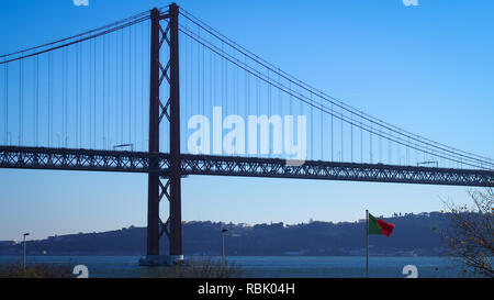 Bandiera portoghese sul 25 de Abril Bridge sfondo, Lisbona, Portogallo Foto Stock