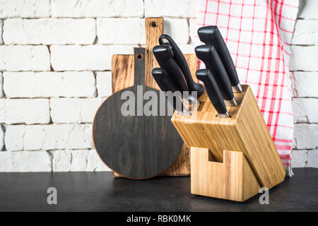 Coltelli da cucina set, taglieri e asciugamano sulla cucina tabl Foto Stock