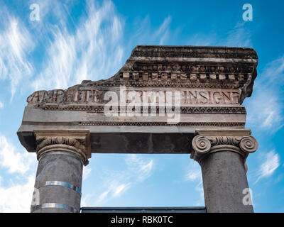 Dettaglio della porta di ingresso dell'antico Anfiteatro greco-romano di Catania, su uno sfondo con cielo blu. Visualizzazione verticale Foto Stock