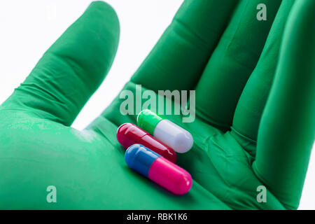 Medico sostiene nella sua mano alcune pillole di bianco Foto Stock