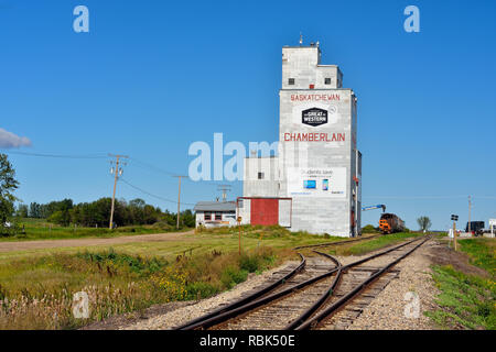 Il vecchio stile elevatori delle granaglie e la linea ferroviaria in tarda estate, Chamberlain, Saskatchewan, Canada Foto Stock