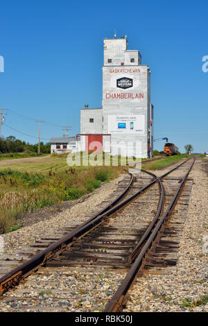 Il vecchio stile elevatori delle granaglie e la linea ferroviaria in tarda estate, Chamberlain, Saskatchewan, Canada Foto Stock