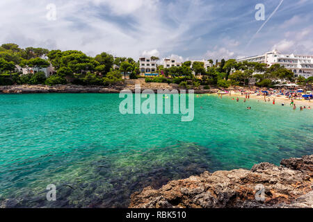 Cala Gran spiaggia con acque turchesi affollate di turisti in Mallorca, Spagna Foto Stock