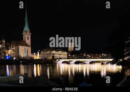 Zurigo, ZH / Svizzera - Gennaio 4, 2019: tempo di notte vista dello skyline della citta' di Zurigo con il fiume Limmat in inverno Foto Stock